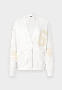 Cardigan branco feito de um tecido suave, com decote em V, bolsos frontais, um grande número "6" em bege e detalhes às riscas nas mangas.