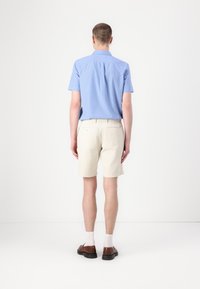 Blåstribet kortærmet skjorte, beige shorts, brune sko, hvide sokker. Simpelt design, standard pasform, rene linjer, bomulds materiale.