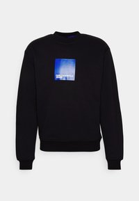 Felpa nera con collo rotondo, polsini e orlo a costine. Presenta un logo rettangolare blu con "KARL LAGERFELD JEANS" in bianco.