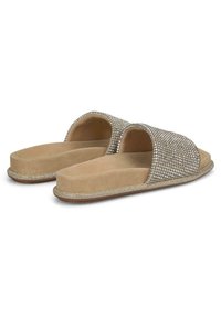 Beige slippers met open teen en hak, versierd met metalen rhinestones op de bovenkant, zachte suède-achtige textuur en platte zool.