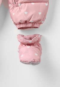 Roze gewatteerde babywant en slofjes set met witte hartpatronen, elastische manchetten en zachte fleece voering op een witte achtergrond.