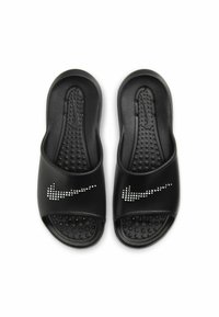 Crne klizne sandale s teksturiranom podlogom, s bijelim Nike logom ukrašenim malim točkicama, izrađene od mekane sintetičke tkanine.