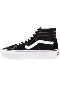Sneaker alto in bianco e nero con lacci bianchi, suola spessa bianca e design a onda bianco sul lato.