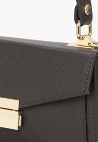 Czarna skórzana torebka o teksturowanym wykończeniu, z metalowym zapięciem w kolorze złotym i detalami, kanciastym designem oraz wyraźnie zarysowanym kształtem.