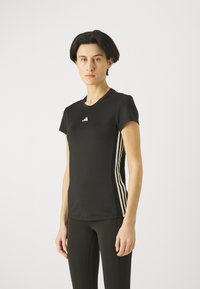 Mustan urheilut-paidan, jossa on lyhyet hihat, rintamalla valkoinen Adidas-logo ja kummallakin sivulla kolme pystysuoraa valkoista raitaa.