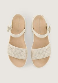 Sandalias de color beige claro con una banda metálica trenzada en la parte delantera, correa ajustable en el tobillo y plantilla acolchada para mayor comodidad.