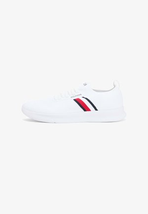 Biały niski sneaker z białymi sznurowadłami, czerwonymi i granatowymi paskami po boku oraz logo "Hilfiger" nad paskami.