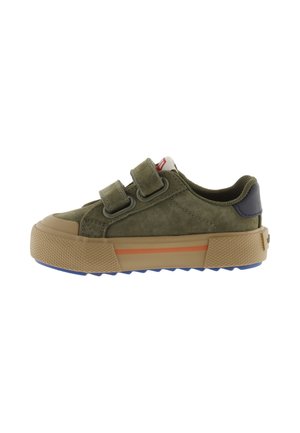 Baskets basses vert olive avec deux bandes Velcro, semelle en caoutchouc beige avec une bande orange et semelle extérieure texturée bleue.