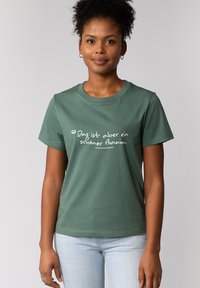 Groene katoenen t-shirt met witte tekst dat zegt "Das ist aber ein schöner Bahn." Korte mouwen en een ronde hals.