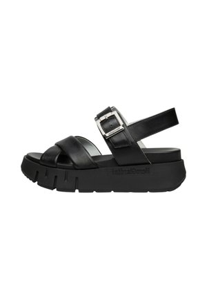 Sandalo platform nero con suola spessa scanalata, cinturini incrociati frontali e cinturino regolabile alla caviglia con fibbia argento.