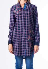 Camicia a quadri blu navy e rosa con maniche lunghe, ricamo floreale sul petto e sulla tasca, e chiusura frontale con bottoni.