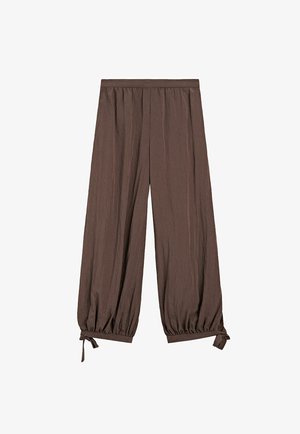 Brune bukser med vide ben, elastiske manchetter og små bundne sløjfer ved anklerne, med en rynket talje og tekstureret stof.