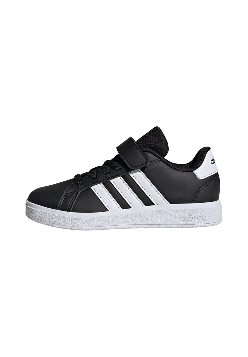 Černá sportovní bota s bílými pruhy, syntetický svršek, polstrovaný límec a suchý zip. Zahrnuje bílou gumovou podrážku se značkováním.
