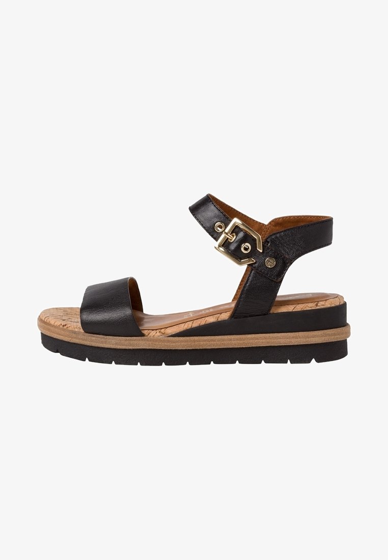 Black leather sandal with adjustable buckle, cork-like midsole, and rubber outsole. Open toe and ankle strap design for comfort.