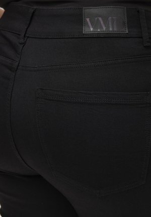 Svarta jeans i skinny-modell med en slät textur. Har en VMD-logotyp på midjebandet, detalj vid bakfickan och en åtsittande design.