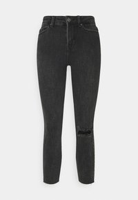 Mustat farkut, joissa on kapea malli. Ominaisuuksiin kuuluu keski-korkeavyötärö ja kulunut polvi repaleisilla reunoilla. Sujuva pinta ja tiukka muotoilu.