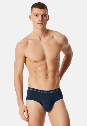 Slip blu navy scuro con una texture liscia, vita elastica con il logo "SCHIESSER" e design aderente.