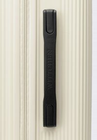 Valigia beige con superficie texturizzata; presenta un manico in plastica nera impresso con "WITTCHEN" per una presa sicura. Dettagli della cerniera visibili.
