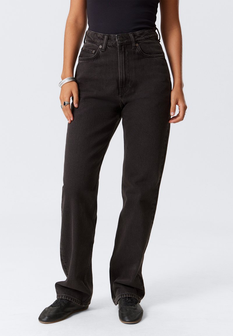 Hoch geschnittene schwarze Denim-Jeans mit geraden Beinen, die über fünf Taschen und einen Knopfverschluss verfügen. Der Stoff ist robust und hat eine leicht strukturierte Oberfläche.
