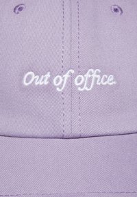 Fioletowa czapka baseballowa z teksturowanej tkaniny, z wyszytym w białym kolorze napisem "Out of office". Klasyczny zakrzywiony daszek.