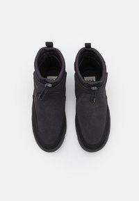Schwarze Knöchelstiefel aus Wildleder und synthetischen Materialien, mit glatter Textur, runder Zehenform und verstellbaren Schnürsenkeln für einen individuellen Sitz.