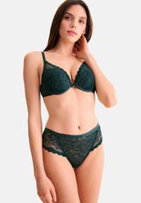 Ensemble de lingerie en dentelle vert foncé comprenant un soutien-gorge légèrement rembourré avec des bords festonnés et des culottes en dentelle assorties avec des motifs floraux.