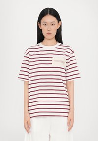 Hvid og burgunderstribet kortærmet t-shirt med en brystlomme, der har trykt tekst. Blødt bomuldsstof, afslappet pasform.