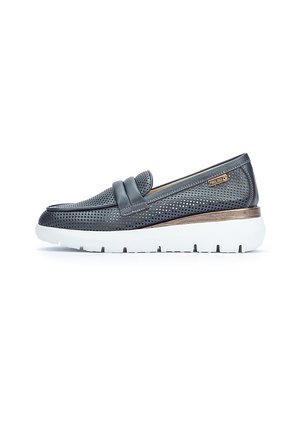 Scarpa slip-on in pelle grigia forata con suola bianca spessa e dettagli in bronzo, caratterizzata da una fascia decorativa sulla parte superiore.