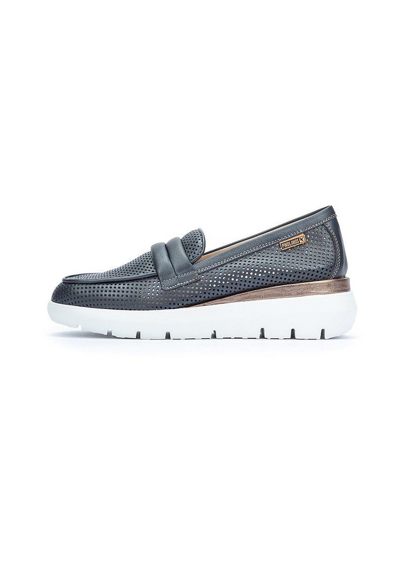 Scarpa slip-on in pelle grigia forata con suola bianca spessa e dettagli in bronzo, caratterizzata da una fascia decorativa sulla parte superiore.