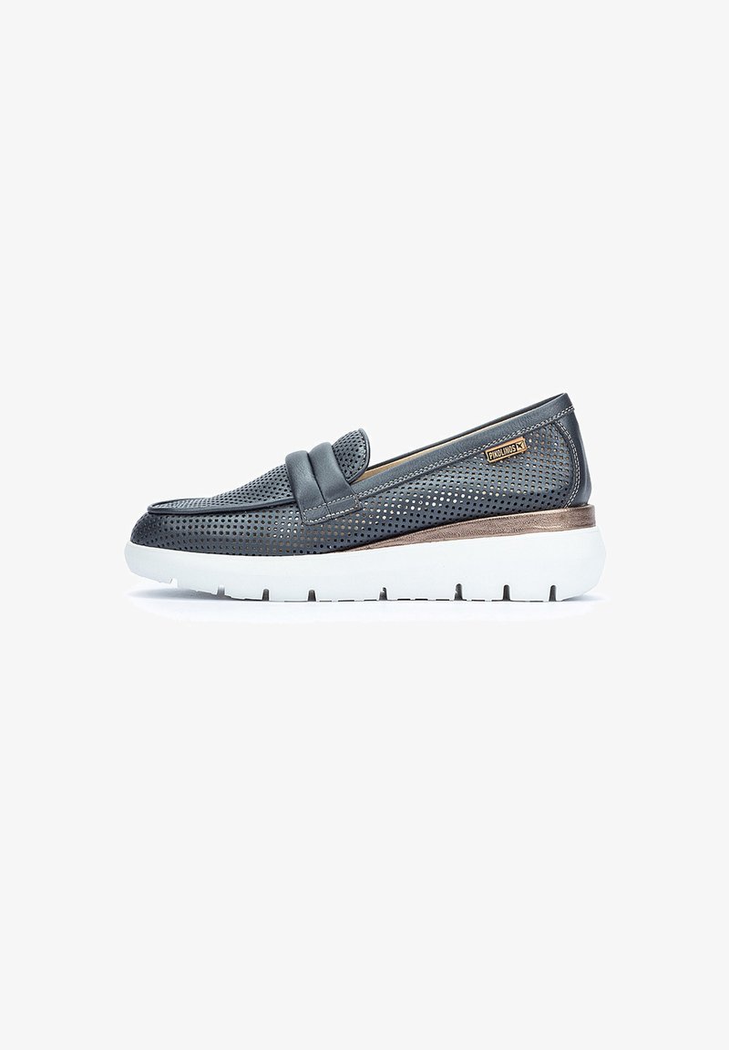 Scarpa slip-on in pelle grigia forata con suola bianca spessa e dettagli in bronzo, caratterizzata da una fascia decorativa sulla parte superiore.