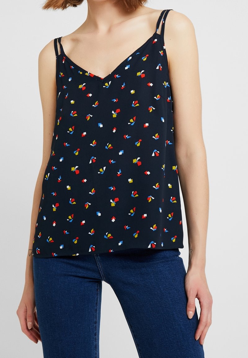 Camisole marine avec décolleté en V, bretelles étroites et imprimé géométrique coloré en rouge, jaune, vert et bleu ; tissu léger, coupe décontractée.
