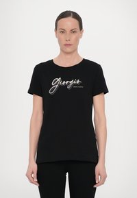 Mustmustärane puuvillane T-särk lühikeste varrukatega, ümar kaelus, millel on hõbedases kirjas trükitud tekst "Giorgio" ja "Armani Exchange".