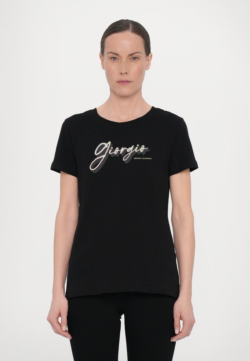 Mustmustärane puuvillane T-särk lühikeste varrukatega, ümar kaelus, millel on hõbedases kirjas trükitud tekst "Giorgio" ja "Armani Exchange".