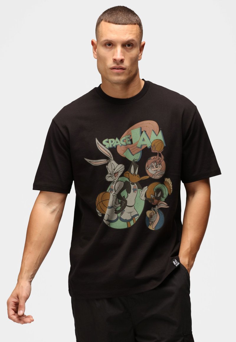 Sort bomulds T-shirt med et farverigt grafisk tryk af tegneseriefigurer og "SPACE JAM" tekst. Korte ærmer, rund hals, afslappet pasform.