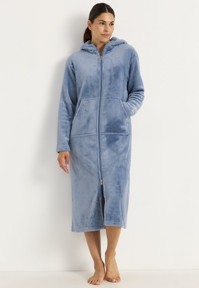 Fleece zip-up morgonrock i ljusblått, med huva, långa ärmar, två sidofickor och hel dragkedja. Mjuk textur, längd till mitten av vaddern.