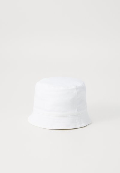Sombrero blanco de algodón, con una corona redonda y un ala ancha que se inclina hacia abajo. Textura suave con detalles cosidos.