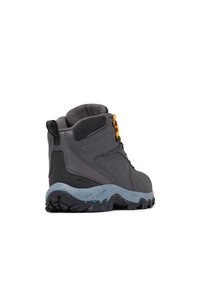 Scarponi da trekking impermeabili grigi con superficie testurizzata, collare imbottito e dettagli arancioni negli occhielli. Suola intermedia blu con macchie e suola nera robusta.