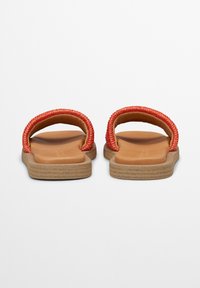 Red woven strap sandals with a tan cushioned footbed and textured beige sole, featuring a minimalistic design without additional accents.