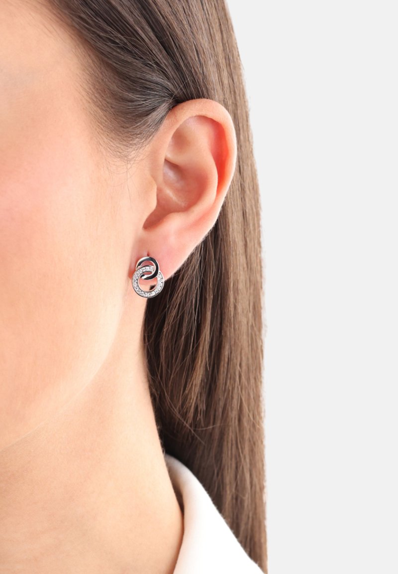 Orecchini a cerchio in tonalità argento con un design intrecciato, caratterizzati da una superficie liscia e testurizzata, impreziositi da piccoli cristalli scintillanti.