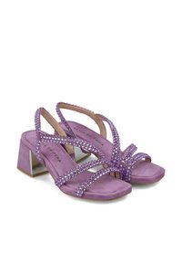 Lila Wildleder-Absatzsandalen mit mehreren glitzernden Riemen und einem quadratischen Absatz mit reflektierenden Akzenten. Glatte Textur. Flache Sohlen.