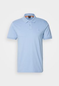 Polo bleu clair à manches courtes avec col, deux boutons et un logo carré embossé subtil sur la poitrine gauche.