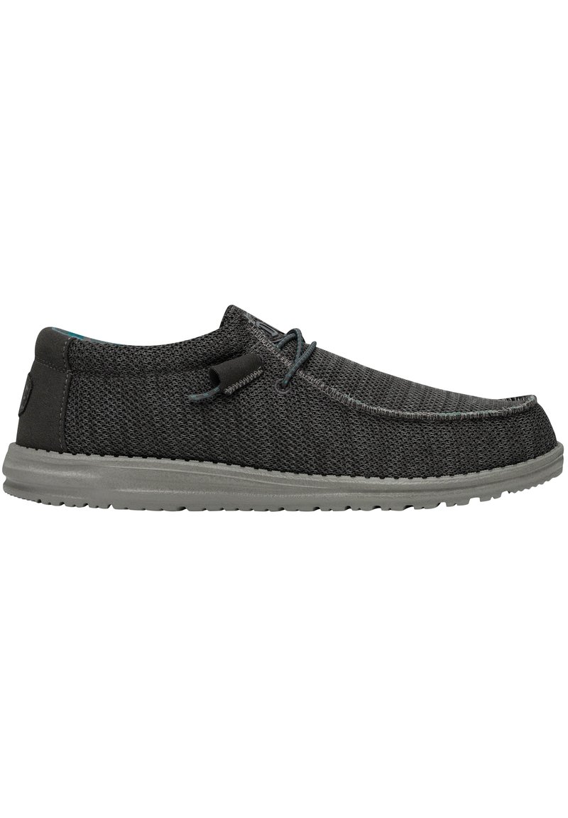 Czarne buty wsuwane o teksturowanej siateczkowej cholewce, szarej gumowej podeszwie i minimalistycznych akcentach sznurowania. Okrągły czubek i niski profil.