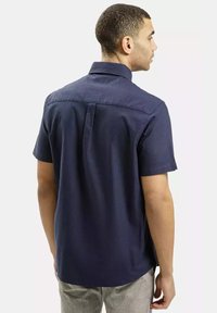 Granatowa koszula krótki rękaw z mieszanki bawełny, z kołnierzykiem zapinanym na guziki, z tylnym karczkiem i dopasowanym krojem. Gładka struktura bez widocznych wzorów.