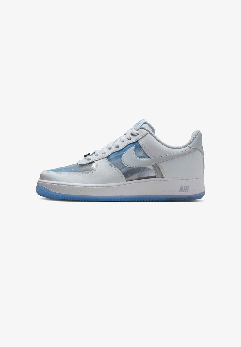 Witte lage sneaker met doorschijnende blauwe panelen, witte Nike-swoosh, witte veters en blauwe zool, zij-aanzicht tegen een witte achtergrond.