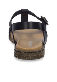 Sandalo in pelle nera con suola piatta in sughero texturizzato. Presenta un design semplice con una singola cinghia regolabile e accenti hardware minimalisti.