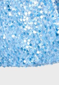 Tissu bleu densément couvert de sequins bleus brillants et ronds créant une surface texturée étincelante.