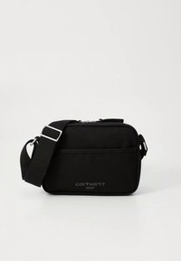 Melnas neilona plecu soma ar regulējamu siksnu, rāvējslēdzēja augšdaļu, priekšējo kabatu un reljefa "carhartt WIP" logotipu priekšpusē.