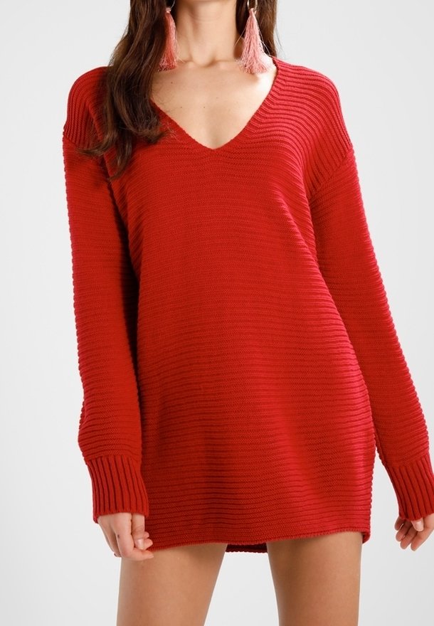 Rotes Strickkleid mit V-Ausschnitt, langen gerippten Ärmeln und lässiger Passform, das ein strukturiertes Muster aufweist.