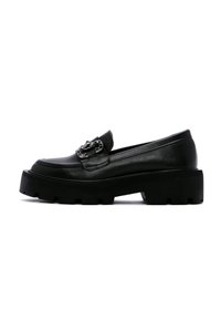 Mocassins en cuir noir avec une semelle épaisse, présentant un accent en chaîne métallique sur le dessus et une texture lisse.