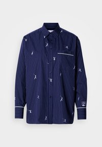 Chemise bleu marine à boutons avec rayures blanches et figures brodées ludiques. Comprend une poche appliquée et un bord contrastant blanc sur les poignets.